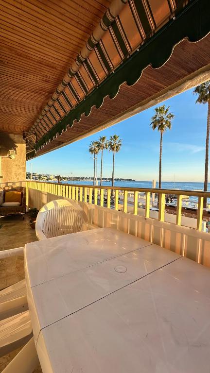 - une terrasse couverte avec une table et des chaises sur la plage dans l'établissement Paradou on the beach, amazing view, 3 beds, à Antibes