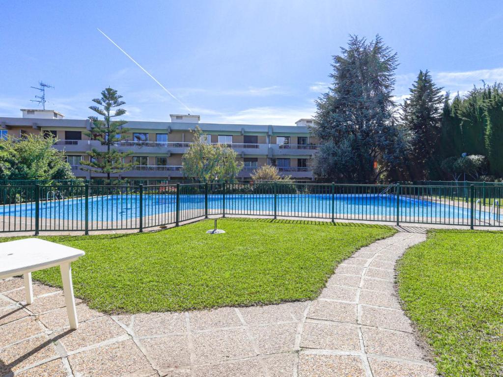 une clôture à côté d'une piscine avec un bâtiment dans l'établissement Studio Ciel de Fabron by Interhome, à Nice