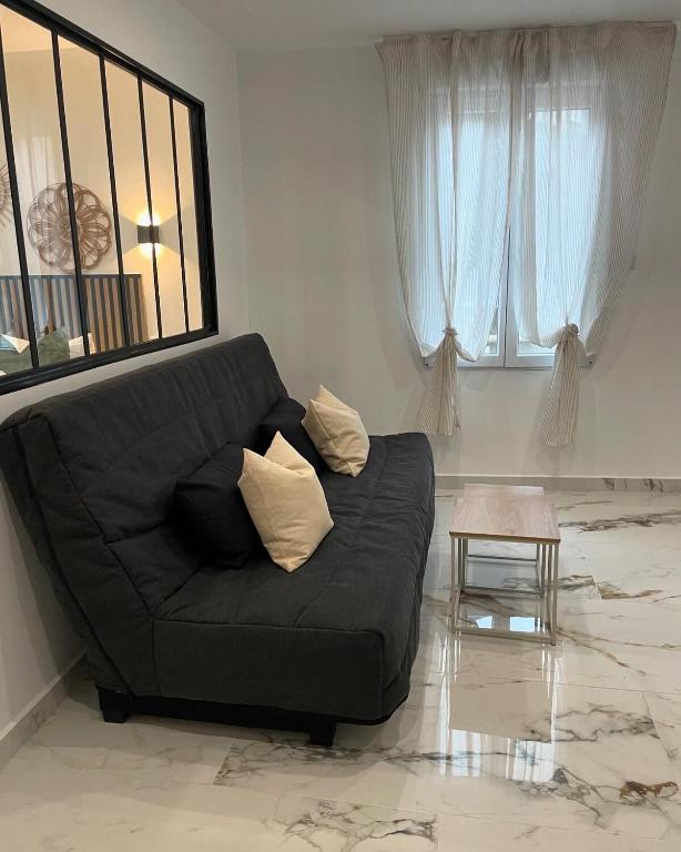 Sofá negro en una sala de estar con ventana en Appartement T2 proche de la gare, en Arles