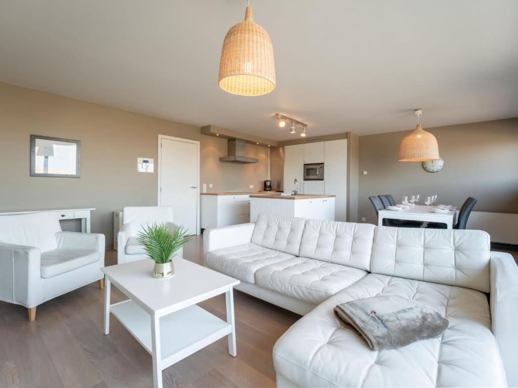 a living room with a white couch and a table at Apartment Albatros by Interhome in Bredene