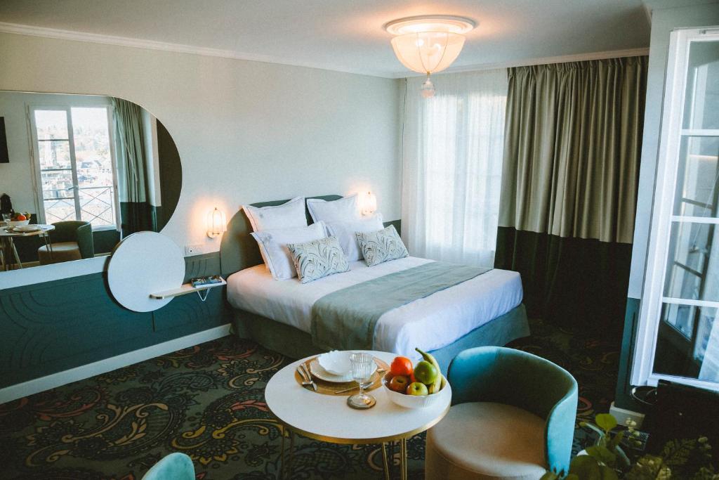una camera d'albergo con un letto e un tavolo con frutta di Le Berceau de La Source a Bagnères-de-Bigorre