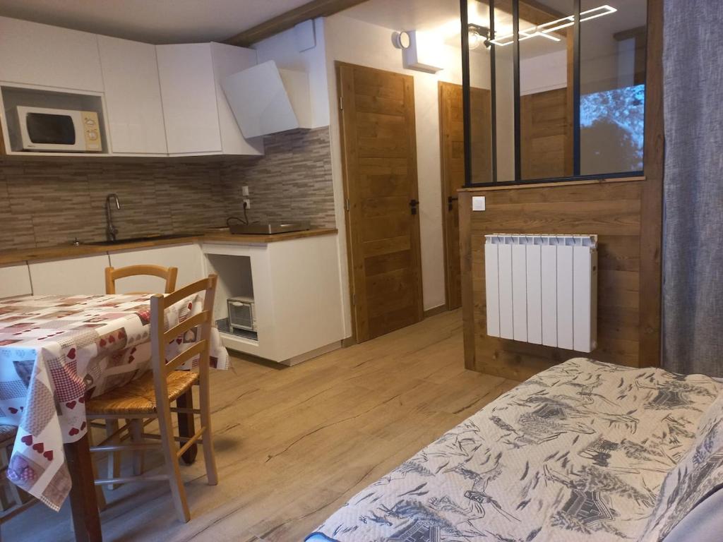 een keuken en een eetkamer met een tafel en stoelen bij Sur le TMB Les Contamines in Les Contamines-Montjoie