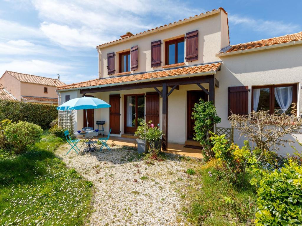ein Haus mit einer Terrasse und einem Sonnenschirm in der Unterkunft Holiday Home Le Predaire by Interhome in Pornic
