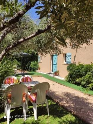 2 chaises et une table dans la cour dans l'établissement Appartement Cavalaire sur Mer, à Cavalaire-sur-Mer