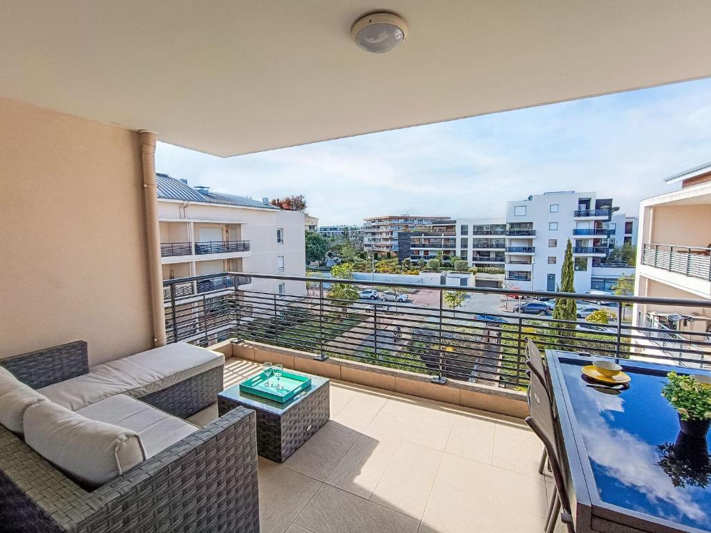 d'un balcon avec un canapé et une vue sur la ville. dans l'établissement Apartment Le 4 Mats-2 by Interhome, à Fréjus