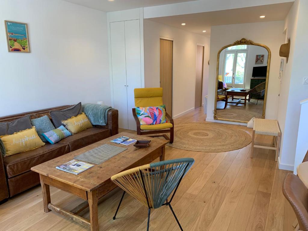un soggiorno con un divano e un tavolo di DUPLEX REP 10 COEUR de COLLIOURE avec parking proche a Collioure