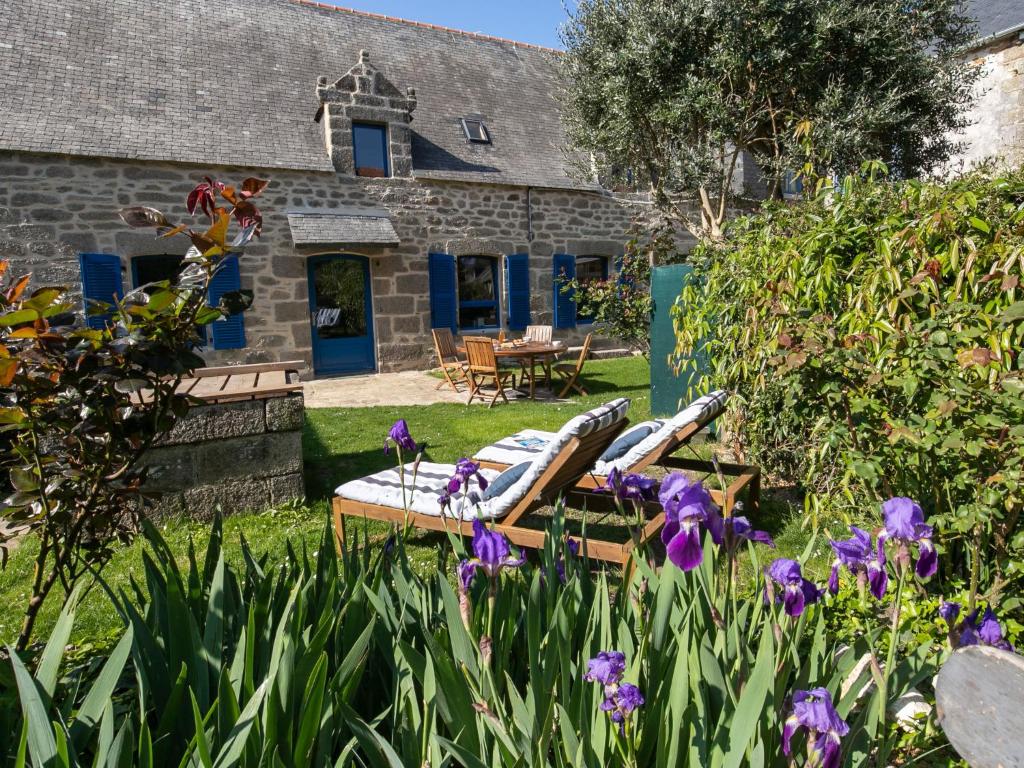 una casa de piedra con sillas y flores en el patio en Holiday Home Maison Duquesne by Interhome, en Concarneau