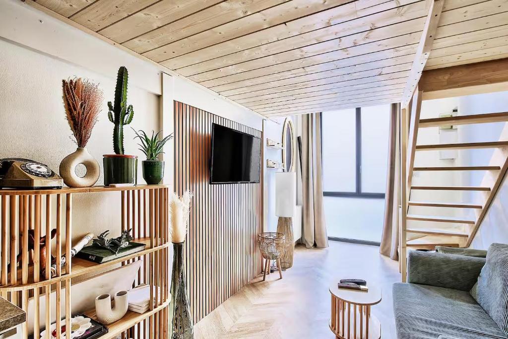 un salon avec un canapé et un escalier dans l'établissement Le Nid Suspendu, à Lyon