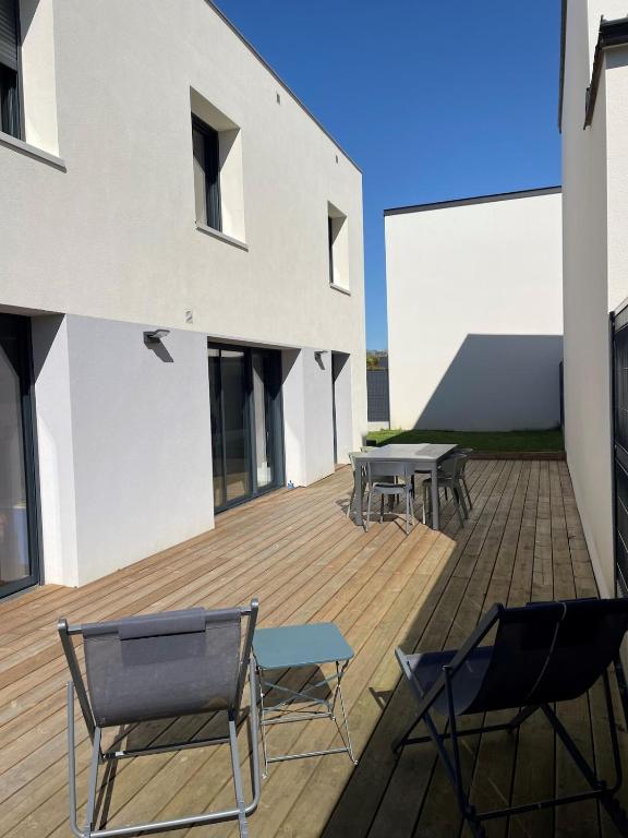 une terrasse avec des chaises et des tables dans un bâtiment dans l'établissement House with terrace and garden, à La Celle-sous-Gouzon