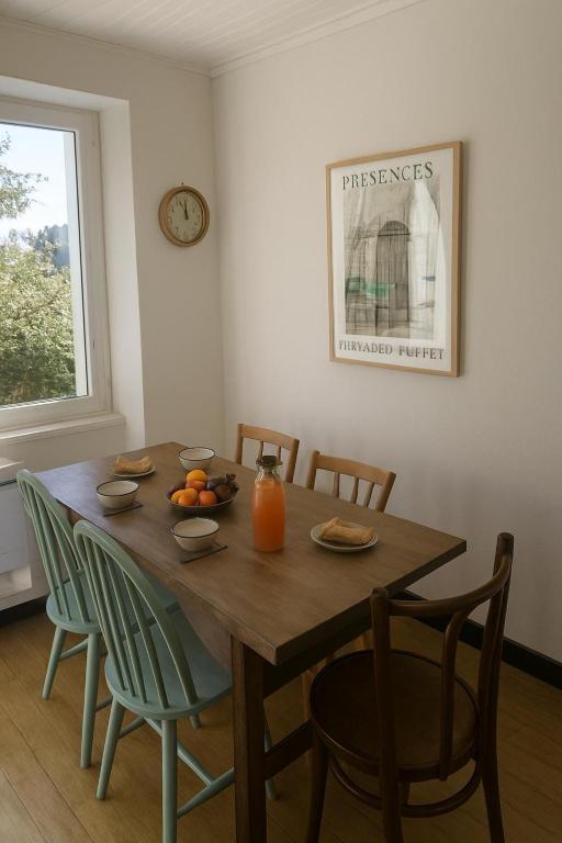 - une table à manger avec des chaises et des oranges dans l'établissement Maison à 2 kms de la Plage, à Plomeur