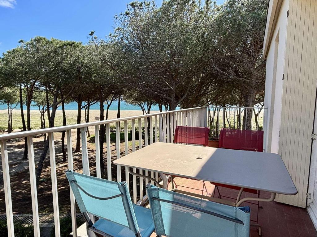une table et des chaises sur un balcon avec la plage dans l'établissement Appartement 2 Pièces - Front de Mer à Argelès-sur-Mer - FR-1-225-667, à Argelès-sur-Mer