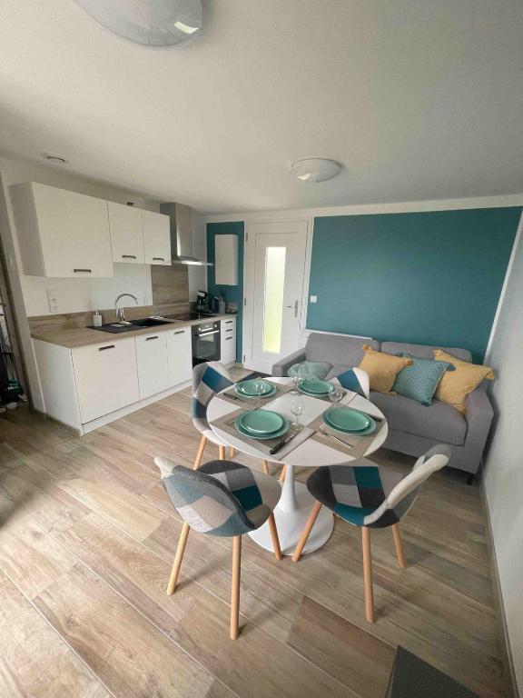 a kitchen and a living room with a table and chairs at Le petit Chatel in Hattonchâtel