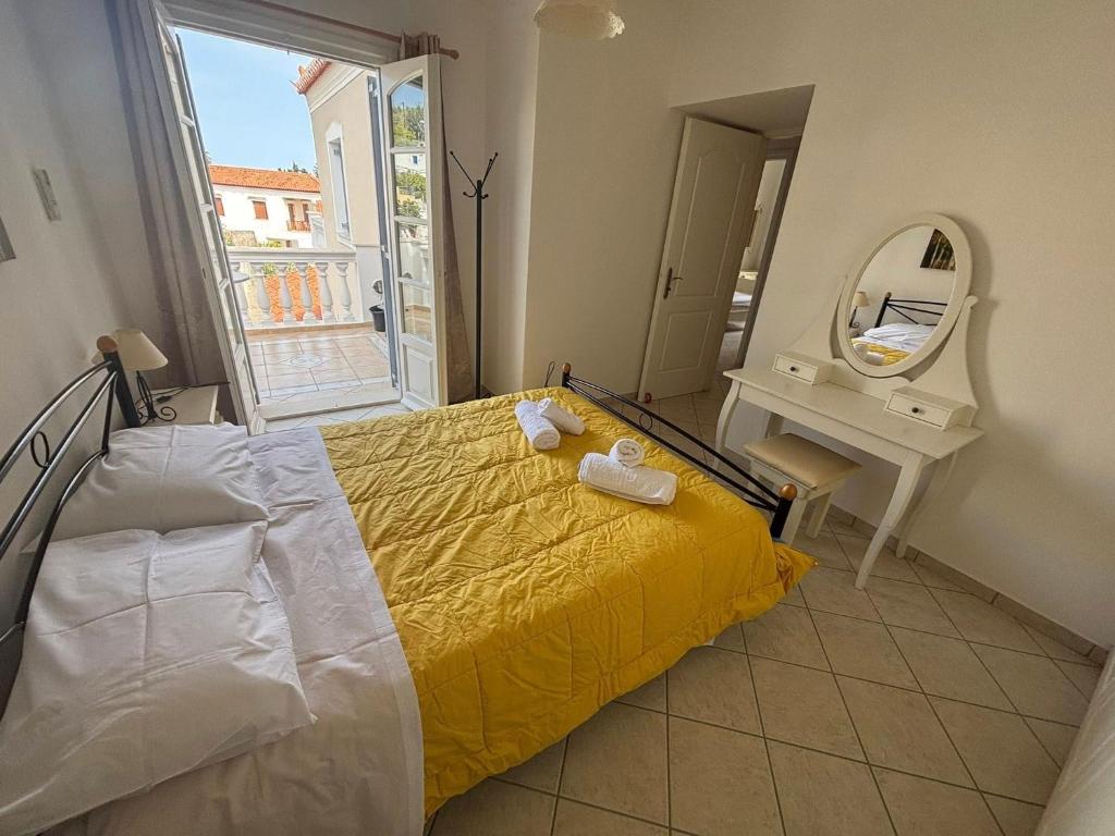 a bedroom with a yellow bed and a mirror at Theo House in Spetses