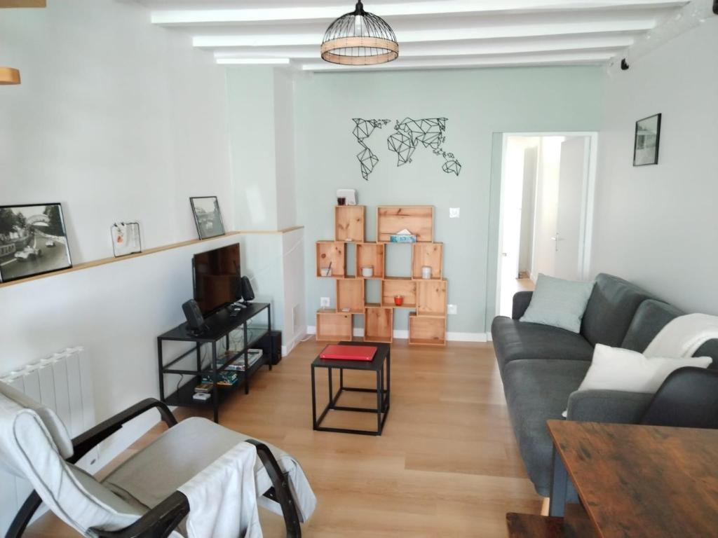 un salon avec un canapé et une table dans l'établissement L'yvréenne, à Yvré-lʼÉvêque