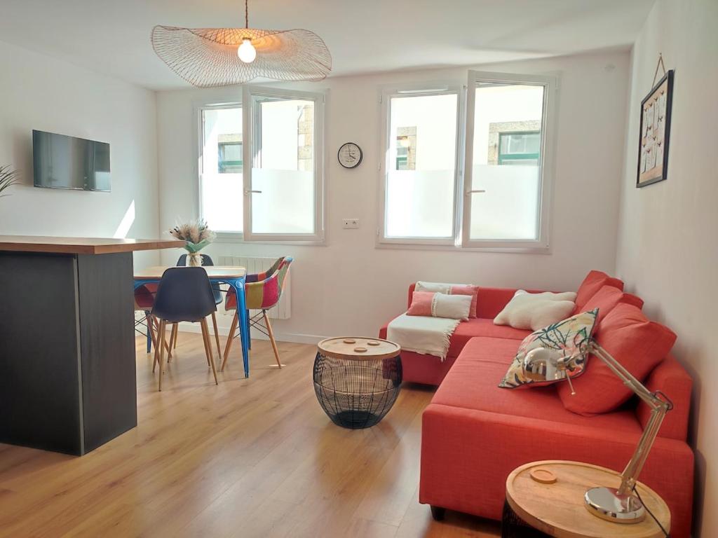 un salon avec un canapé rouge et une table dans l'établissement Terra Marine - T2 - Centre ville, à Concarneau