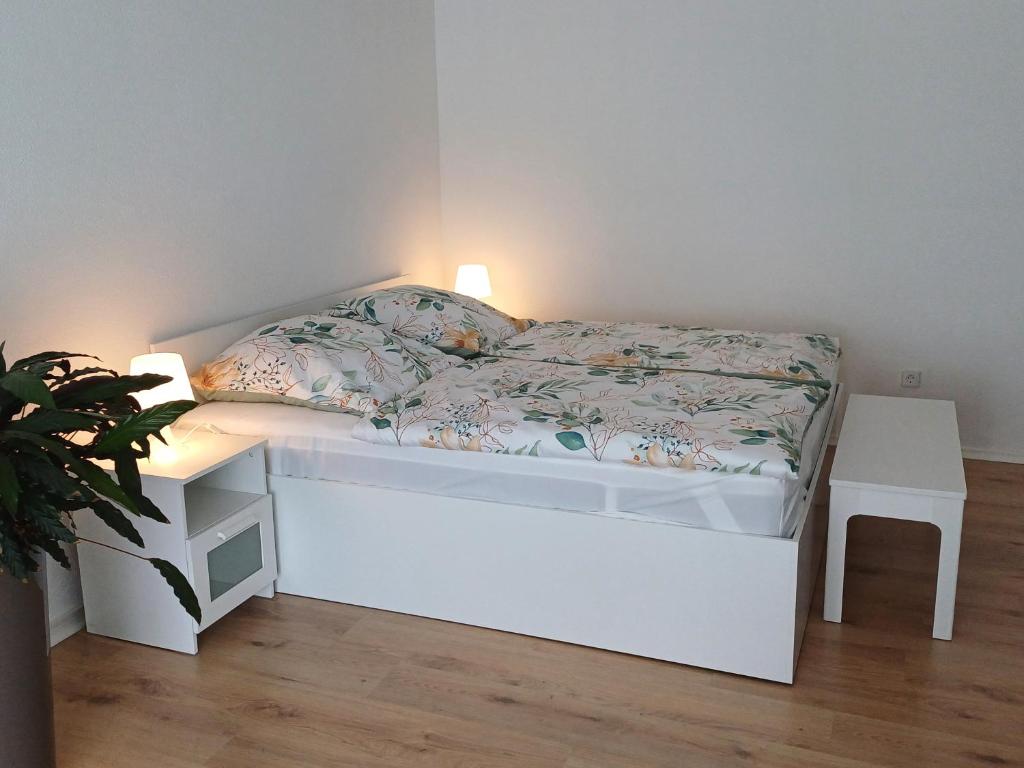 Bad ÜberkingenにあるFerienwohnung Maurerのランプが置かれた部屋にある白いベッド