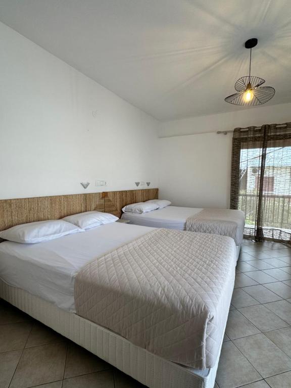 two beds in a bedroom with a ceiling at Tsimiklis Apartments in Finikounta