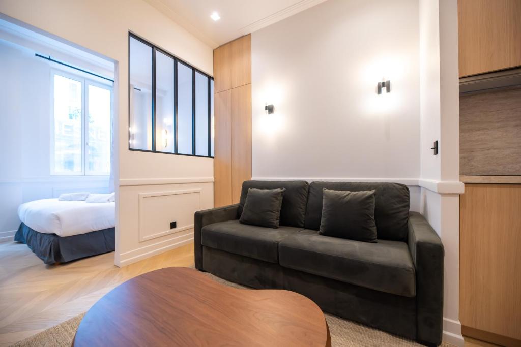 un salon avec un canapé et un lit dans l'établissement Austerlitz-Bastille Residence, à Paris