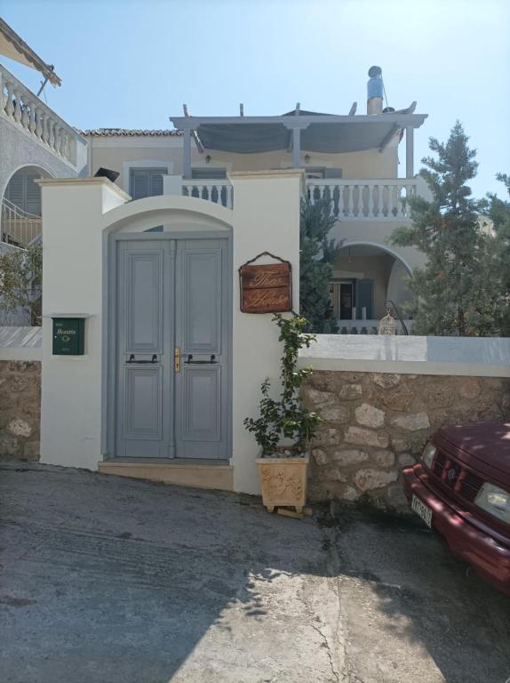 a house with a blue door in front of it at Theo House in Spetses