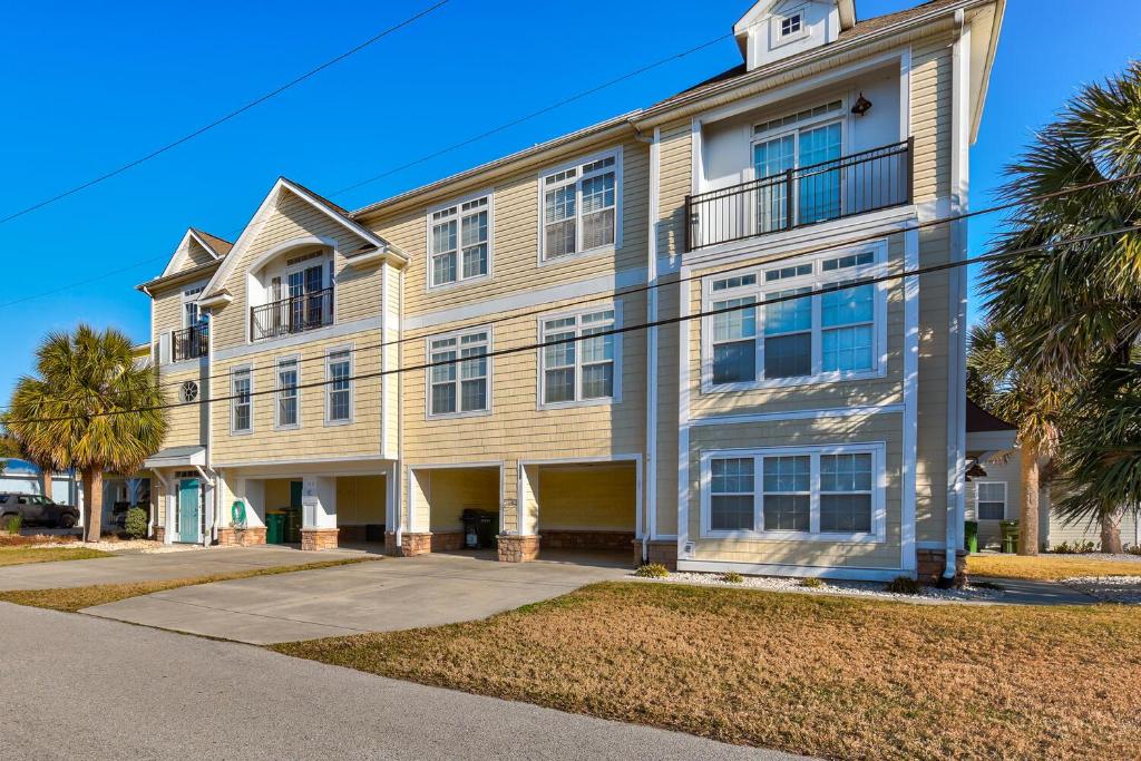a large building with palm trees in front of it at Chateau Maizenbleu by Carolina Beach Realty in Kure Beach