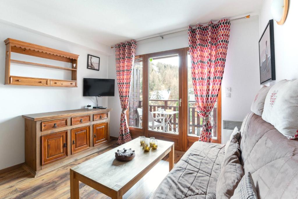un salon avec un canapé et une table dans l'établissement Au coeur de la station pour 8 personnes, à Saint-Étienne-en-Dévoluy