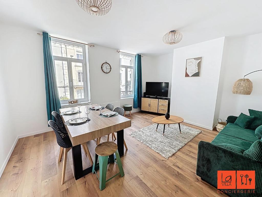 - un salon avec une table et un canapé vert dans l'établissement Le Petit Edmond, à Wimereux