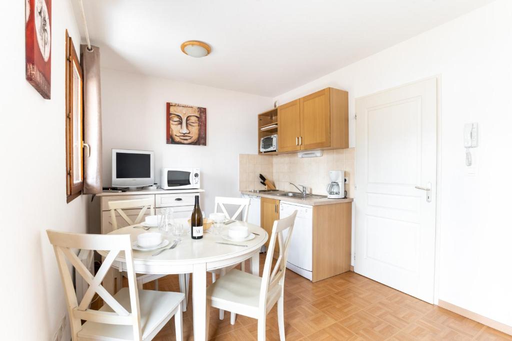 une cuisine et une salle à manger avec une table et des chaises dans l'établissement La Joue du Loup, appartement pour 4, balcon, à Saint-Étienne-en-Dévoluy