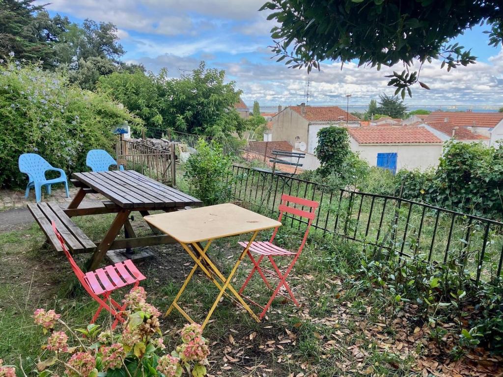 - une table de pique-nique et quatre chaises dans la cour dans l'établissement Grande maison entre mer et fôret, à La Celle-sous-Gouzon