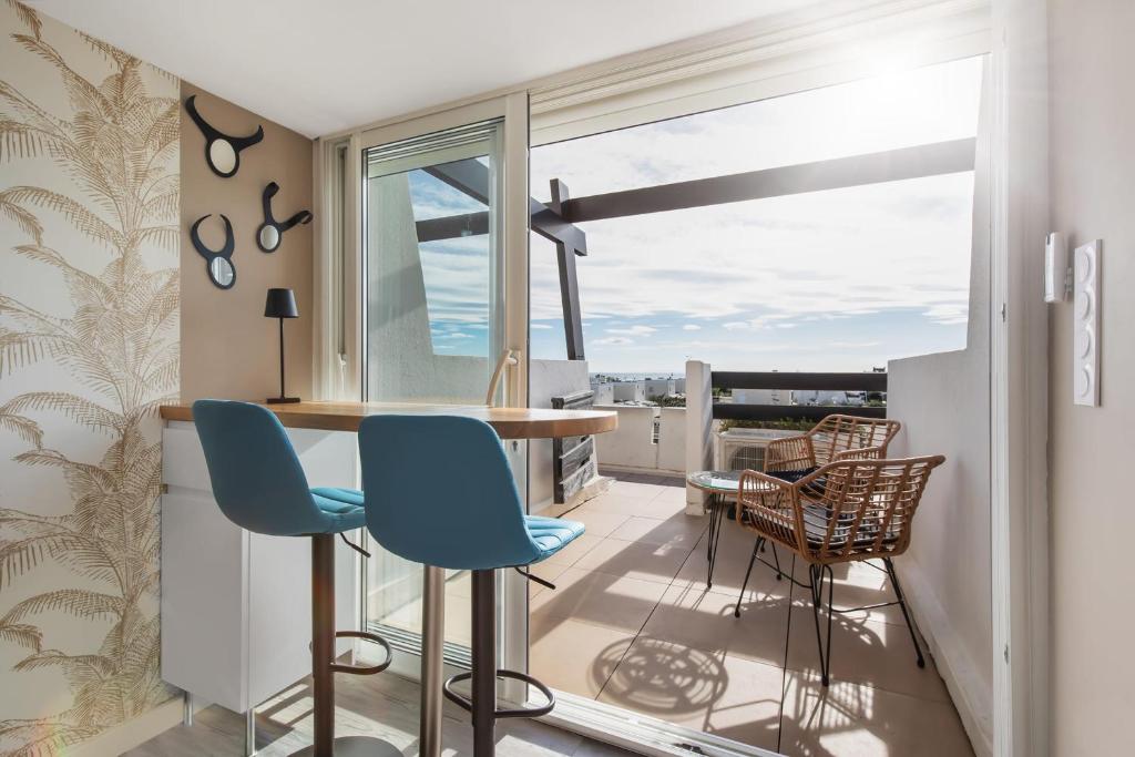 Il dispose d'un balcon et d'une cuisine avec une table et des chaises. dans l'établissement La Boho plage Port Nature, au Cap d'Agde