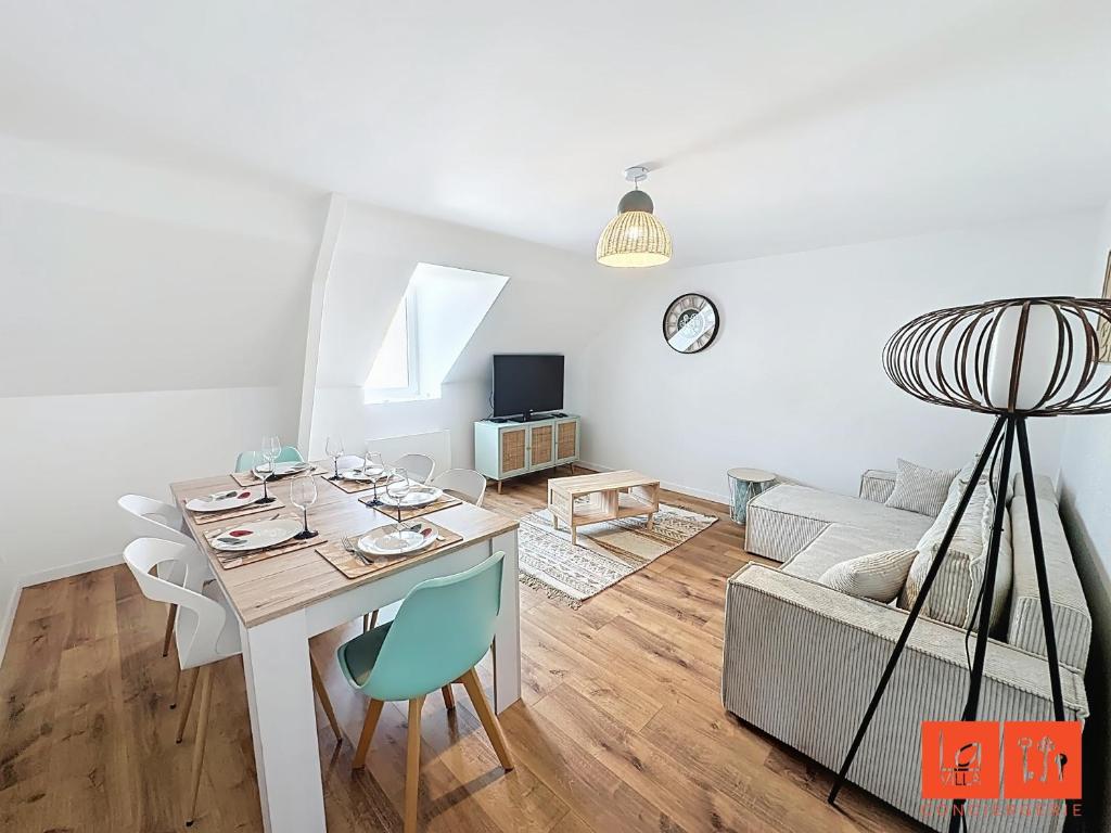 un salon avec une table et un canapé dans l'établissement La Grande Augustine, à Wimereux