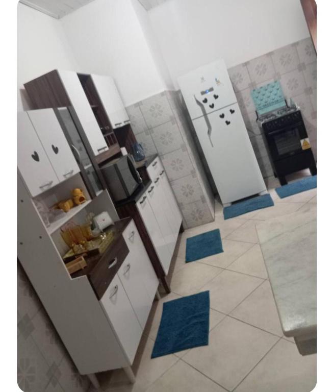 a kitchen with white appliances and blue floor tiles at Apto na Siqueira Campos, centro in Santarém