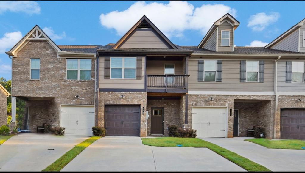 une grande maison en briques avec deux portes de garage dans l'établissement 3bed townhouse in McDonough GA, à McDonough