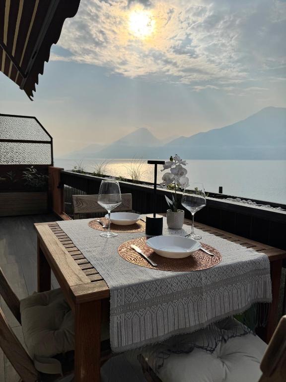 a table with two wine glasses on a balcony at Casa Agnese Lake View in Brenzone sul Garda