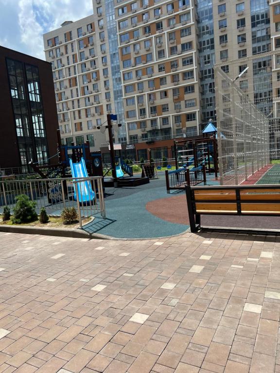 a park bench in a city with tall buildings at Rams in Almaty