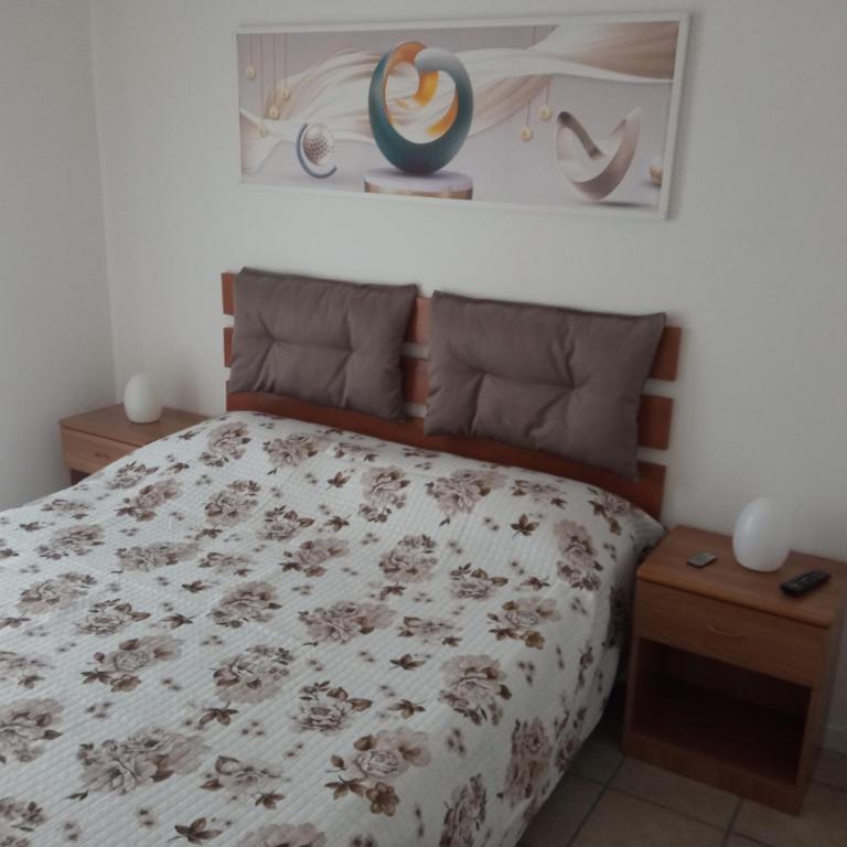 a bedroom with a bed with a floral bedspread at Dolce Relax - Sottomarina in Sottomarina