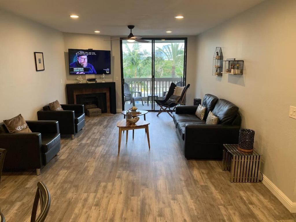 a living room with leather couches and a tv at NEW NEW Gorgeous Condo on the beach in Oceanside