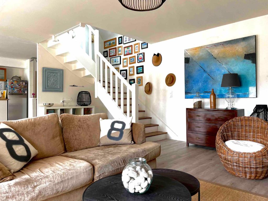 a living room with a couch and a staircase at Ty Glou Maison Charmante - 5m plage in Ploemeur