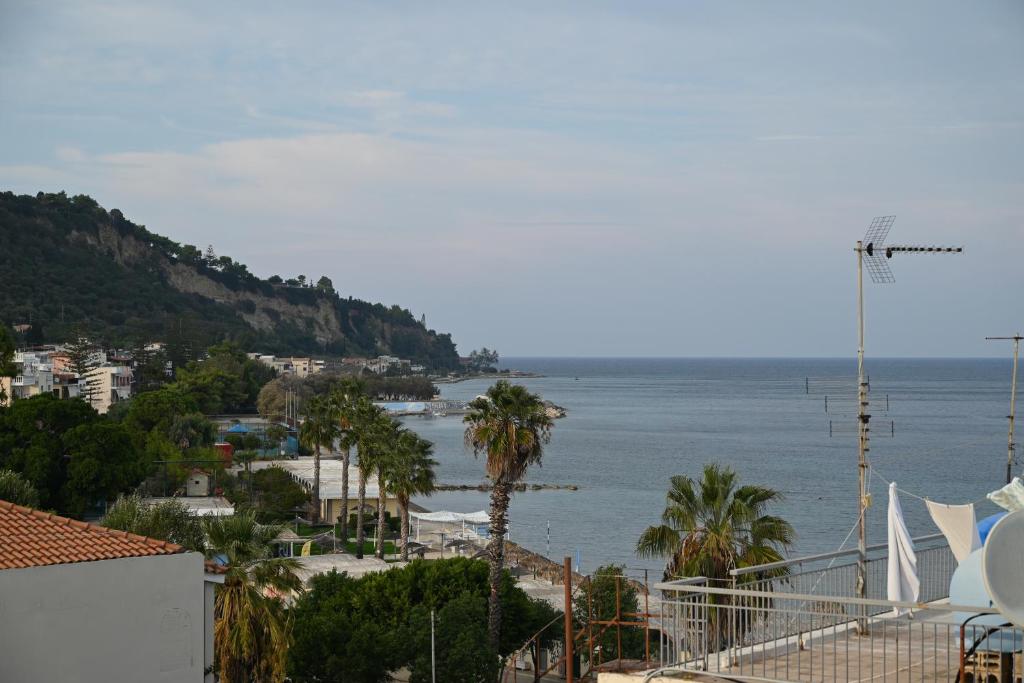 a view of the ocean with palm trees and buildings at Studio Gio in Zakynthos City in Zakynthos