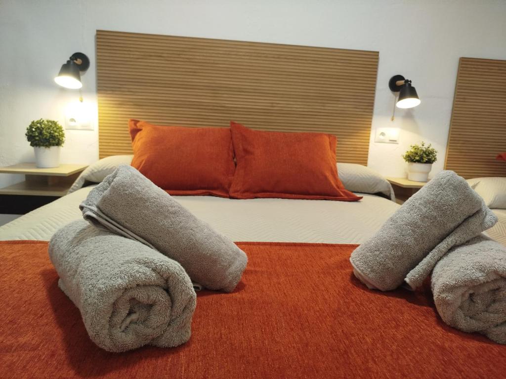 a bedroom with a large bed with towels on it at Casa Lucía - Caminito del rey in Valle de Abdalagís