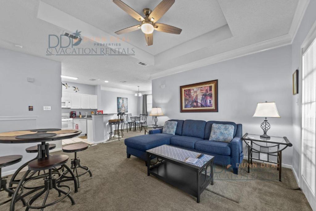a living room with a blue couch and a table at Legacy Villa 504 in Gulfport