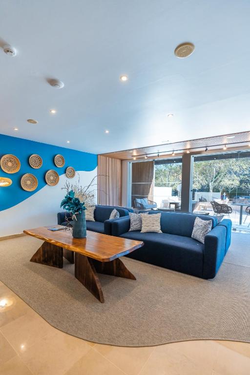 a living room with a blue couch and a wooden table at Carvi Beach Hotel in Lagos