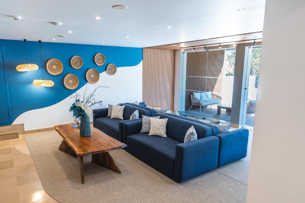 a living room with blue couches and a table at Carvi Beach Hotel in Lagos