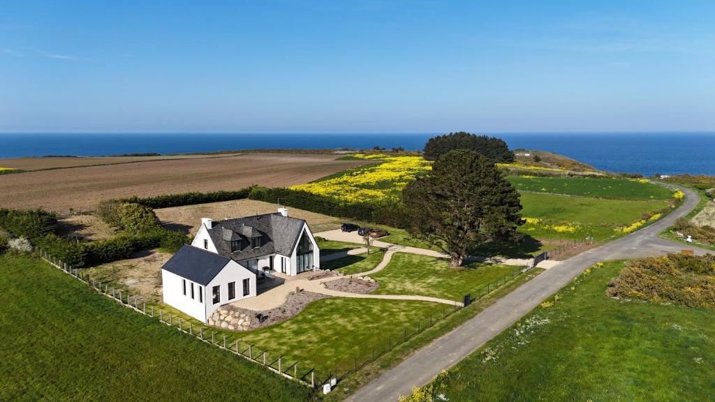 an aerial view of a white house on a hill next to the ocean at Le Clos Minard in Plouézec