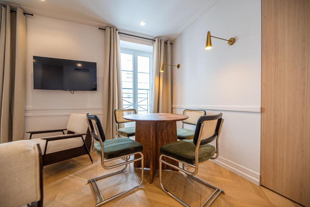 une pièce avec une table, des chaises et une télévision dans l'établissement Relax in Paris XII, à Paris
