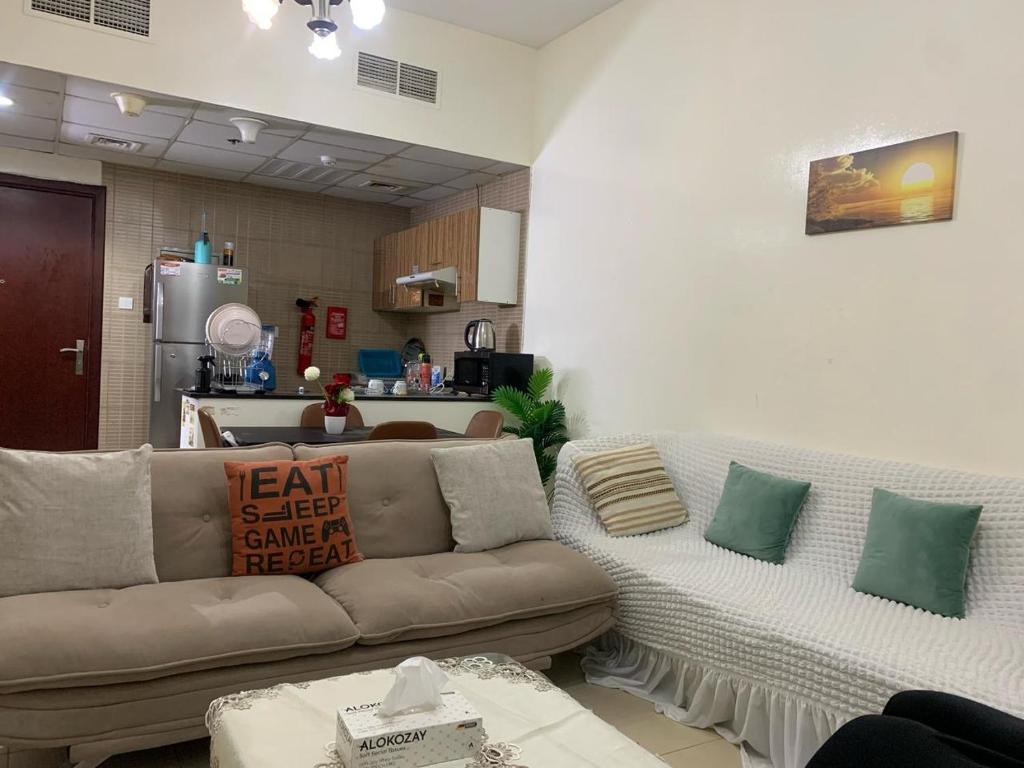 a living room with a couch and a kitchen at city towers ajman in Ajman 