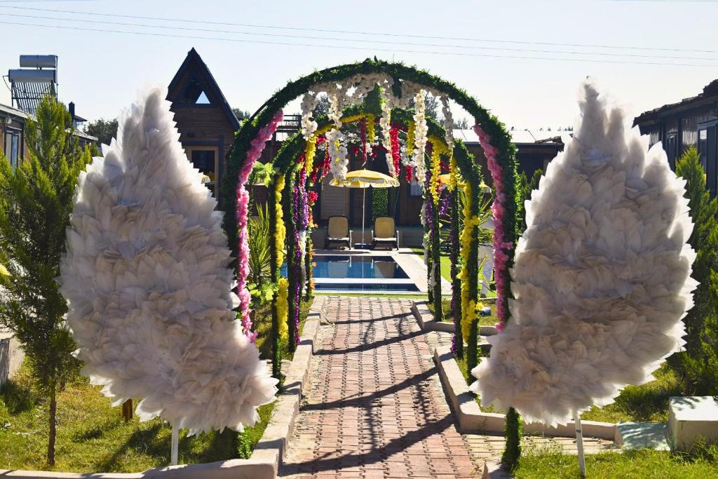 a garden with an arch and a pool at La Bella Bungalov in Dosemealti
