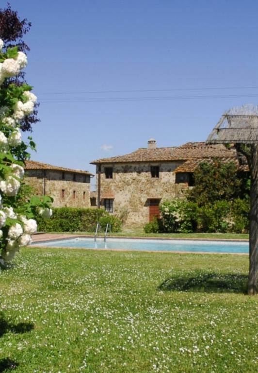 a building with a swimming pool in a yard at Agriturismo Canonica in Greve in Chianti