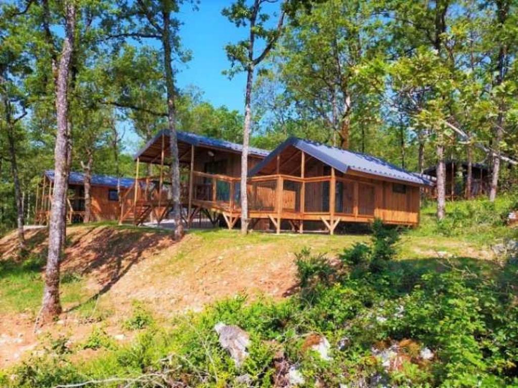 une grande cabane en bois au milieu d'une forêt dans l'établissement Cabane 3 étoiles - Piscine - efchcf, à Saint-Cirq-Lapopie