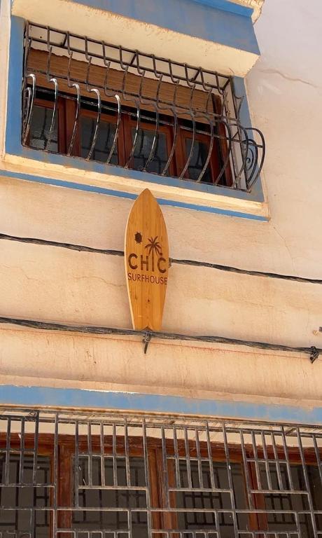ein Holzschild an der Seite eines Gebäudes in der Unterkunft Chic Surf House in Aourir