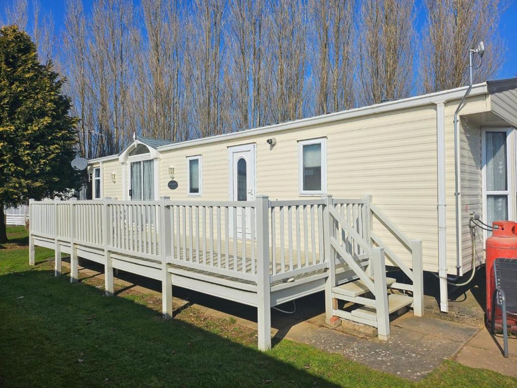 a white mobile home with a white fence at Lovely Caravan At Manor Park, Nearby Hunstanton Beach In Norfolk Ref 23029T in Hunstanton